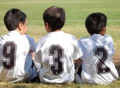 Bambini seduti sull'erba campo di calcio
